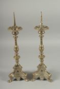 A GOOD PAIR OF PRICKET ALTAR CANDLESTICKS on triangular bases, with claw feet. 19.5ins high.