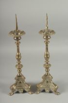 A GOOD PAIR OF PRICKET ALTAR CANDLESTICKS on triangular bases, with claw feet. 19.5ins high.