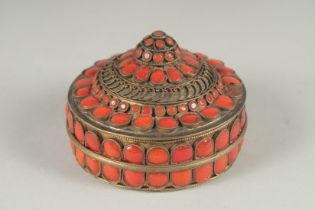 AN INDIAN GILT METAL CIRCUALR BOX AND COVER applied with numerous red enamel inset panels. 3ins