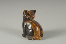 A CARVED TIGER'S EYE CAT with ruby and gold eyes. 2ins high.