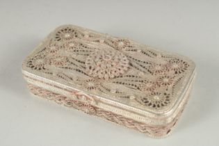 A WHITE METAL FILLIGREE RECTANGULAR BOX, with hinged cover, inset with a red stone. 4.25ins x 2.