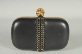 ALEXANDER MCQUEEN. A BLACK LEATHER CLUTCH BAG with skull clasp. 6ins long.