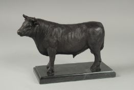 A BRONZE STANDING BULL on a marble base. 9.5ins long.