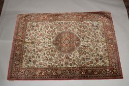 A GOOD PERSIAN SILK CARPET cream ground with floral decoration with a red ground border. Signed. 6ft