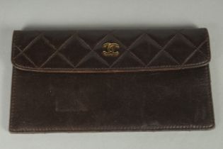 A CHANEL BROWN QUILTED PURSE with gilt double C detail. 7.25ins long.