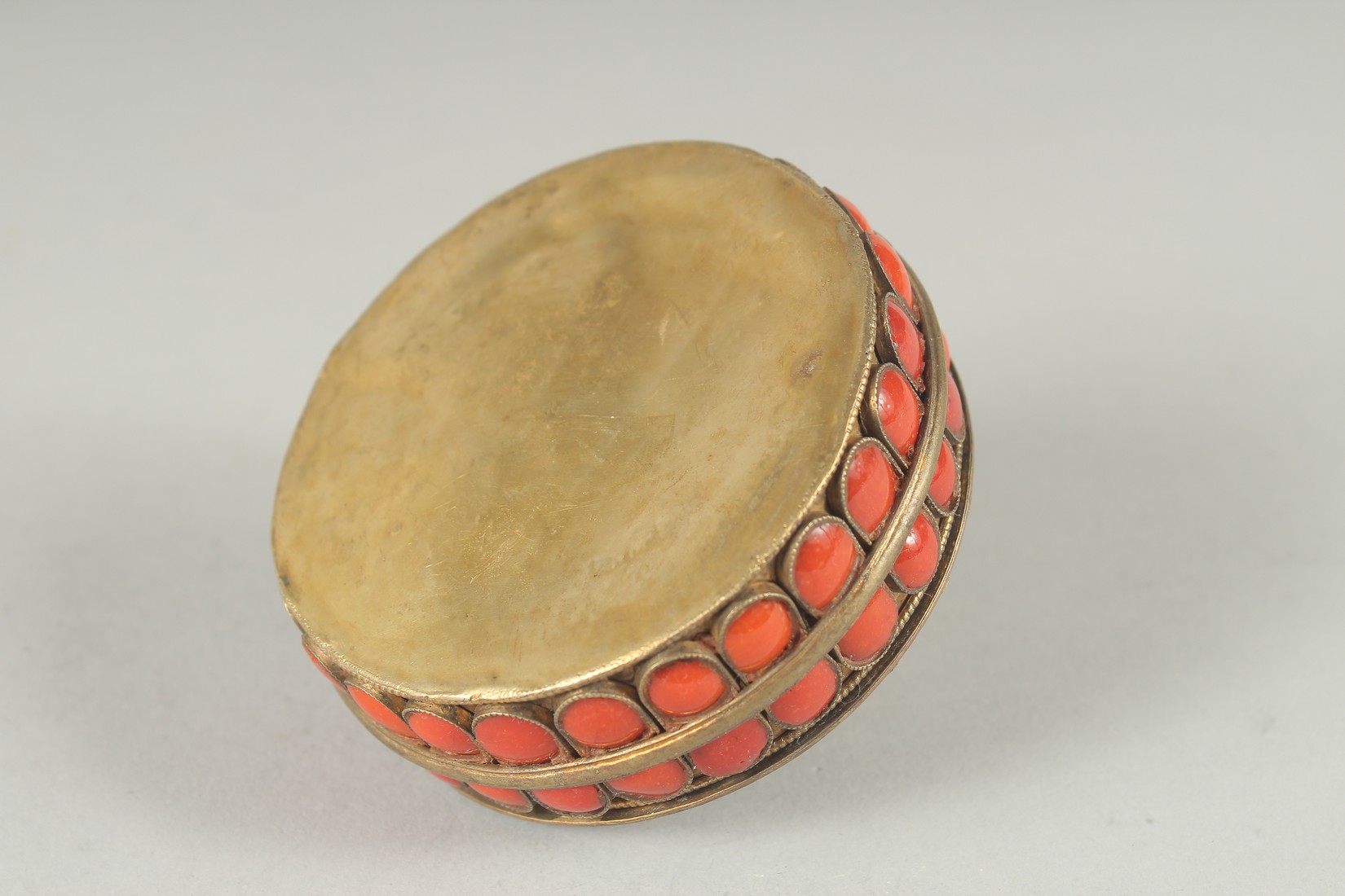 AN INDIAN GILT METAL CIRCUALR BOX AND COVER applied with numerous red enamel inset panels. 3ins - Image 6 of 6