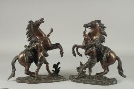 AFTER COUSTOU. A PAIR OF BRONZE MARLEY HORSES AND ATTANDANTS. Signed.