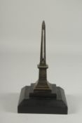 A BRONZE OBELISK THERMOMETER on a square base. 27ins high.