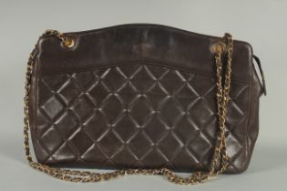 A LARGE CHANEL BROWN SOFT LEATHER PADDED BAG with leather and gilt handles. 16ins lons, 11ins high