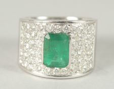 A GOOD 18CT WHITE GOLD EMERALD AND DIAMOND RING set with a central emerald and forty two diamonds.