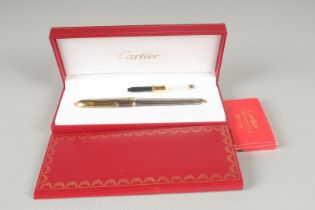A CARTIER PARIS RIBBED TWO COLOUR FOUNTAIN PEN with .750 gold nib. In a red Cartier box with