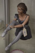 A limited edition Continental pottery model of a seated ballerina.