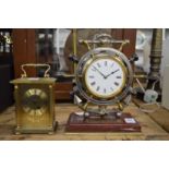 A mantel clock modelled as a ships wheel together with a modern brass carriage clock.