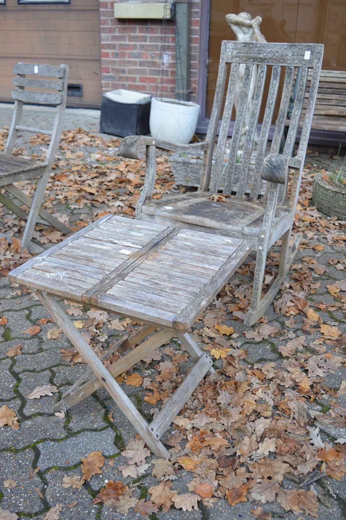 A carved hardwood rocking chair and a folding table.