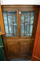 A mahogany four door standing corner cabinet.