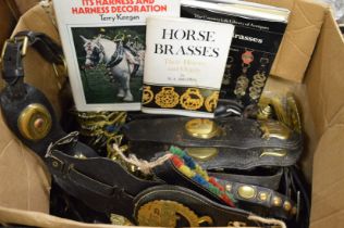 A collection of horse brasses, horse leathers and related books.