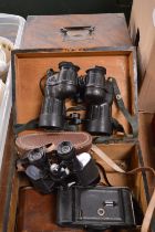 Two wooden boxes containing binoculars and a camera.
