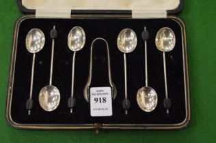 A cased set of coffee bean spoons and sugar tongs.