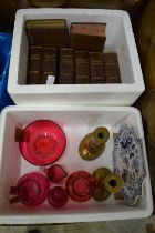 Cranberry glassware, pair of brass candlesticks, blue and white plate and group of books.