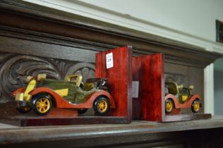 A pair of novelty wooden bookends modelled as cars.