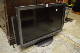 A flat screen TV with speaker system and accessories.