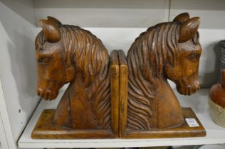 A pair of carved wood horse head bookends.
