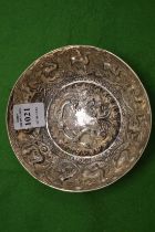 An Eastern white metal circular bowl with embossed decoration.