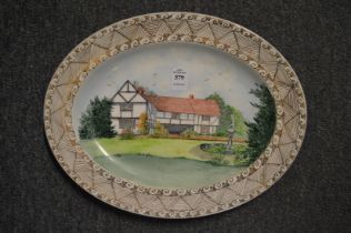 An oval dish, hand painted by Irene Carne, depicting a country house.