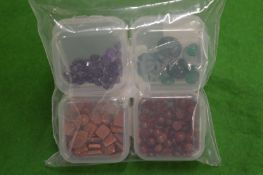 Four small boxes of cabochon stones.