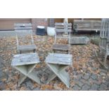 A pair of folding chairs with a pair of occasional tables.