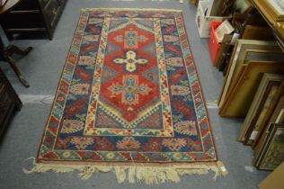 A Persian design rug, red ground with large stylised decoration 215cm x 125cm.