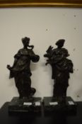 A pair of cast bronze female figures on marble bases.