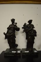 A pair of cast bronze female figures on marble bases.