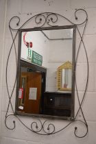 A modern mirror with wrought iron frame.