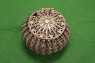 A white metal filigree circular box.