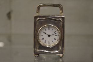 A small silver carriage type clock.