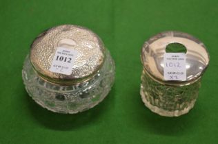 Two silver topped cut glass dressing table jars.