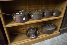 Graduated set of copper saucepans with lids and other items.