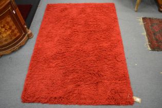 A modern red ground rug 170cm x 120cm.