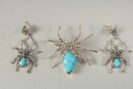 A silver turquoise and marcasite spider brooch and earrings in a box.
