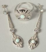A silver and opal Deco style ring and drop earrings in a box.