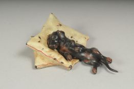A cold painted bronze dog sleeping on a pillow, 8cm.