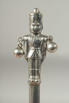 A silver novelty soldier rattle.