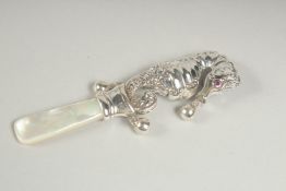 A silver mother of pearl and ruby seahorse rattle.