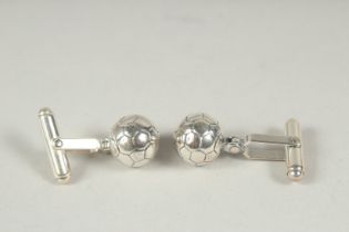 A pair of silver football cufflinks.