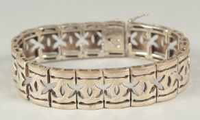 A silver pierced bracelet, in a heart shaped velvet box.