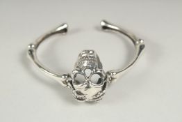 A silver skull bracelet in a velvet box.