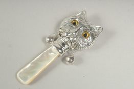 A silver and mother of pearl cat rattle.