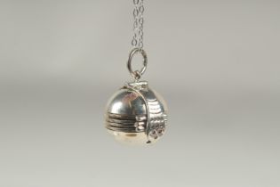 A silver opening ball locket and chain in a box.