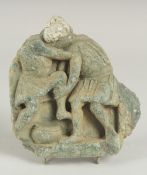 A RARE GANDHARA CARVED STONE TILE FRAGMENT, depicting two men wrestling, 15cm x 14cm.